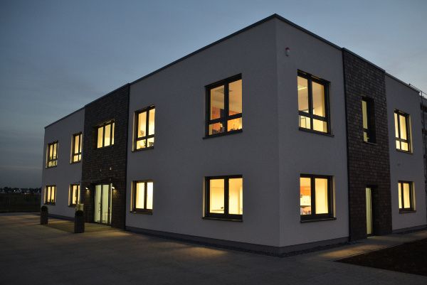 Bürogebäude MicroControl bei Nacht mit beleuchteten Fenstern